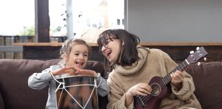 Como despertar nas crianças o interesse por um instrumento musical; mãe toca instrumento de cordas e filha outro de percussão