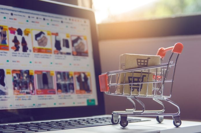 Estudo revela sites de compras online com menor preço em brinquedos; imagem mostra carrinho de supermercado sobre teclado de notebook