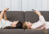 Meninas deitadas no sofá e sorrindo para o celular