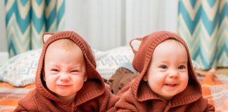 Nascimento de gêmeos atinge níveis sem precedentes, diz estudo; dois bebês gêmeos de capuz marrom, um faz careta e o outro sorri