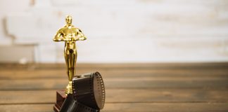 Estátua do Oscar com rolo de filme e pipoca