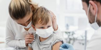 Pesquisa alerta que pais adiaram vacina contra meningite na pandemia; mãe acompanha filho enquanto é vacinado, ambos estão de máscara no rosto