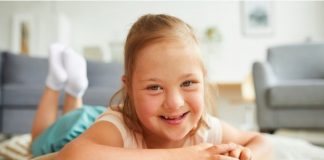 Campanha pede prioridade na vacinação das pessoas com síndrome de Down; menina com síndrome de Down olha sorridente para a câmera