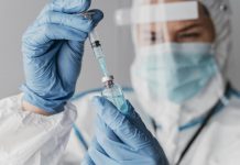 Vacinas: nossa principal esperança no controle da pandemia; pessoa de bata branca, máscara e luvas azuis segura vacina nas mãos