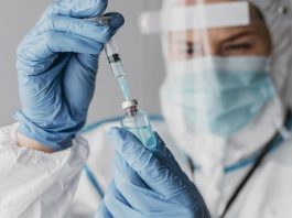 Vacinas: nossa principal esperança no controle da pandemia; pessoa de bata branca, máscara e luvas azuis segura vacina nas mãos