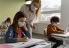 Crianças e professora na escola com máscaras