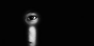 Violência contra criança: como identificar sinais de maus tratos; olho de criança é visto por meio de fechadura em imagem toda preta