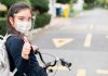 Liberdade sobre rodas: andar de bicicleta ganha mais relevância na pandemia; menina andando de bicicleta com máscara e face-shield