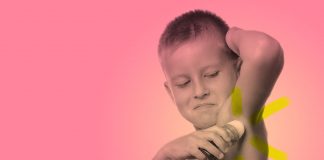 Crianças com mau cheiro nas axilas podem usar desodorante infantil?; menino sem camisa passa desodorante na axila, em imagem de fundo rosa