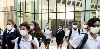Escolas de Nova Iorque reabrem em setembro e ensino remoto será suspenso; alunos de máscara e mochila nas costas caminham