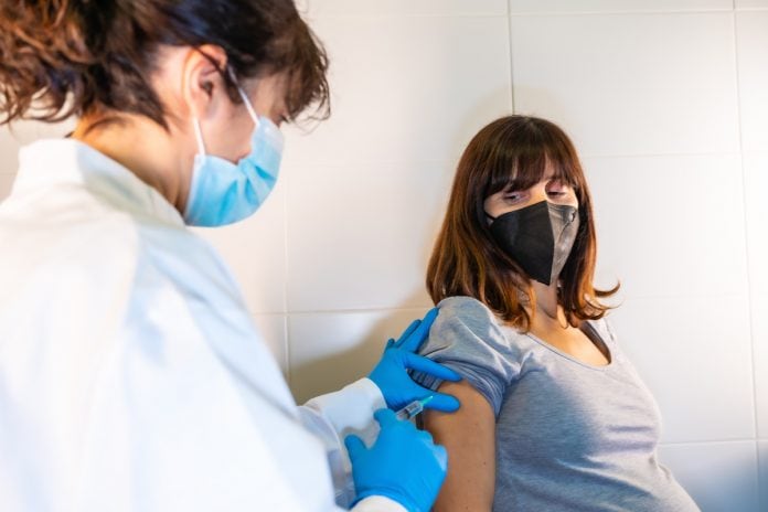 Gestantes e puérperas vacinadas com Astrazeneca devem tomar 2ª dose 45 dias após o parto; grávida de máscara recebe vacina no braço