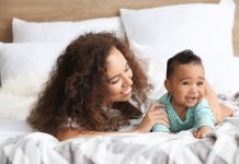 Relação mãe e filho – o primeiro relacionamento que temos na vida; mãe olha para filho, ambos deitados na cama
