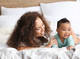 Relação mãe e filho – o primeiro relacionamento que temos na vida; mãe olha para filho, ambos deitados na cama