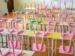 Os efeitos perversos da pandemia na educação; inúmeras cadeiras coloridas apoiadas sobre meses de sala de aula