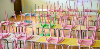 Os efeitos perversos da pandemia na educação; inúmeras cadeiras coloridas apoiadas sobre meses de sala de aula