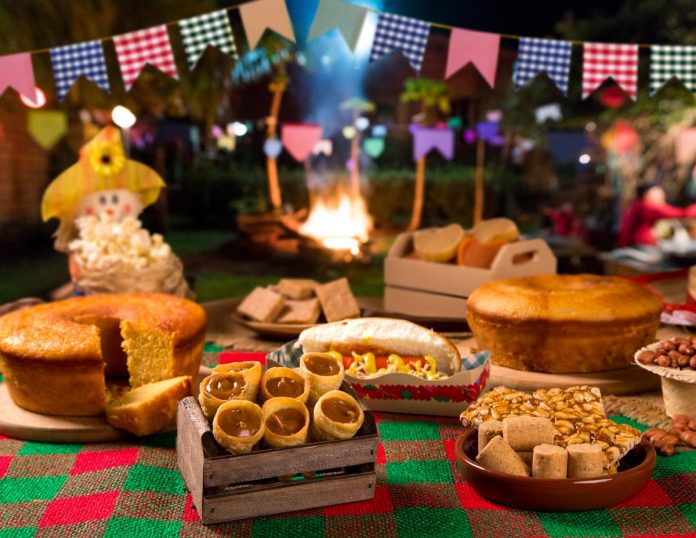Festa junina virtual: dicas de brincadeiras para o arraial híbrido de 2021; imagem mostra comidas juninas e decoração de bandeirinhas