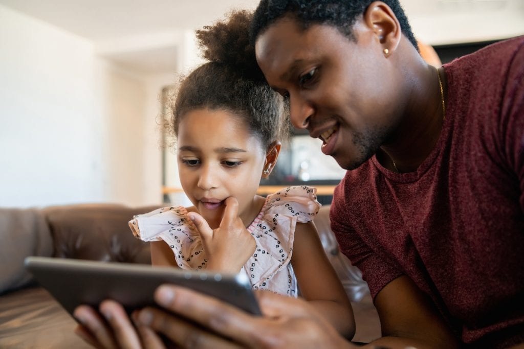Aplicativos para crianças ganham selo de aprovação de educadores; pai e filha olham para tablet