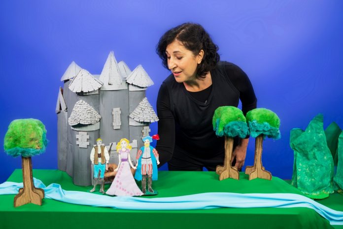 Óperas de Mozart e Carlos Gomes inspiram contação de histórias infantis; mulher contando histórias com cenário e bonecos