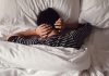 ‘Estresse tóxico’: 52% das crianças tiveram o sono prejudicado na pandemia; menino está deitado na cama de barriga para baixo e com mãos sobre a nuca