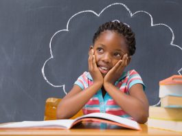 Histórias de fracasso de empreendedores ensinam muito às crianças; menina pensativo com lousa preta atrás e desenho de nuvem com giz branco que a envolve