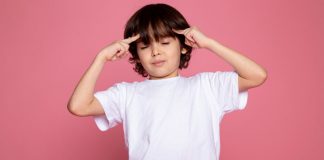Saiba identificar a mentalidade que seu filho desenvolve; menino de olhos fechados apoia dedos sobre laterais da testa