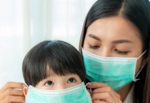 Qual máscara protege mais seu filho contra o coronavírus?; Menina e mãe asiáticas usando máscara cirúrgica