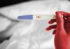 Gravidez precoce no Brasil sofre queda de 37% em 20 anos, diz estudo; mulher segurando teste de gravidez
