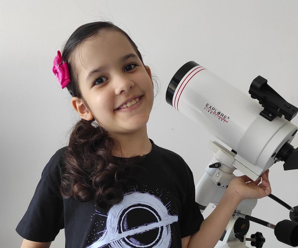 Nicole Oliveira, prodígio de astronomia de 8 anos, já detectou 7 asteroides; Nicole com o seu telescópio