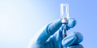 Vacina da Pfizer é segura em crianças entre 5 e 11 anos, dizem fabricantes; Mão de médico com luva azul segura ampola de vacina