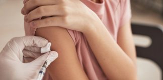 Vacinação de adolescentes: esclarecendo as principais dúvidas dos pais; médico aplicando vacina em adolescente