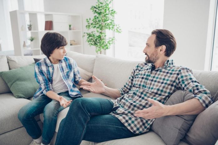 Pai e filho conversando sobre drogas na infância sentados no sofá