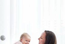 Mulher segurando bebê, ambos sorrindo