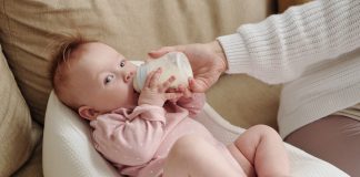 Bebê toma leite na mamadeira