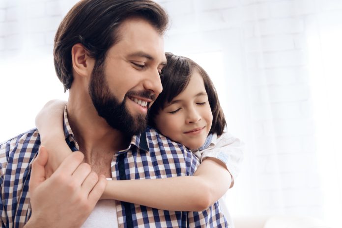 FIlha abraçada ao pai pelas costas; como a cultura do machismo pode prejudicar a criação dos filhos