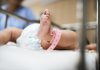 Bebê no berço com pulseira de identificação; Bebês prematuros: quais são as causas para o nascimento antes da hora?