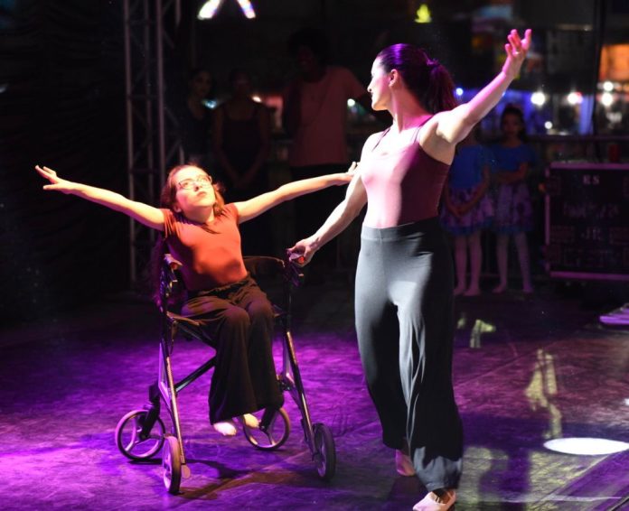 Mônica Pitanga dança no palco com a filha Luisa; dança inclusiva favorece a autoestima e traz vários outros benefícios à pessoa com deficiência