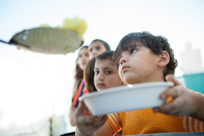 Crianças fazem fila com prato vazio nas mãos, falta de dinheiro para consumo de alimentos é um dos problemas apontados por estudo do Unicef