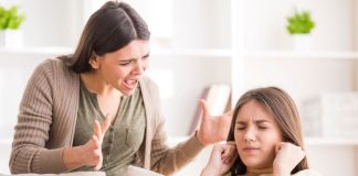 Mãe grita com a filha que tampa os ouvidos com a mão
