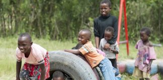 Crianças brincam em pneu velho
