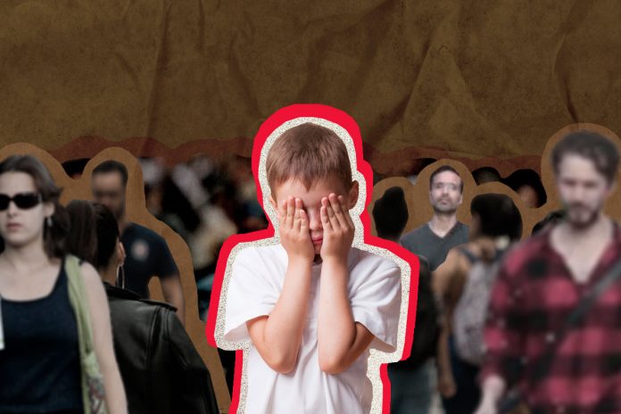Criança com ansiedade social esconde o rosto em multidão de pessoas