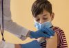 Especialistas esclarecem dúvidas sobre vacinação de crianças; criança de máscara tomando vacina