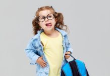 Menina de óculos segurando mochila azul