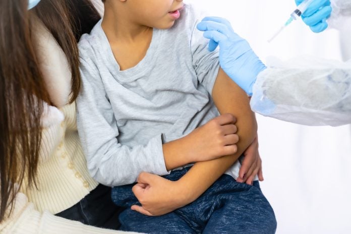 Menina recebe vacina no braço esquerdo