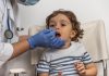 Profissional de saúde aplica cotonete no nariz de criança para teste de Covid