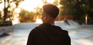 Adolescente negro de costa e moleton em área ao ar livre