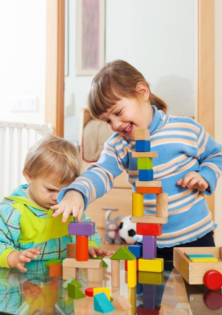 Duas crianças brincando com blocos de empilhar