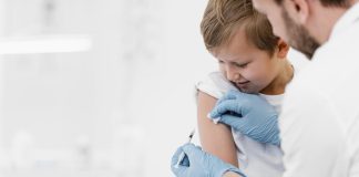 Criança sorrindo ao ser vacinada