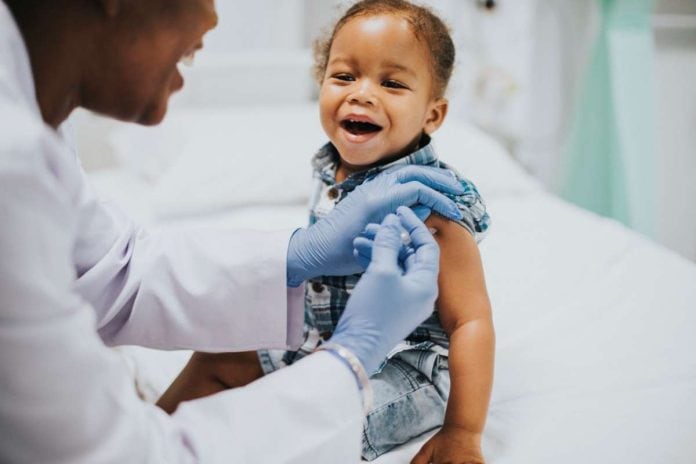 Criança negra recebe vacina no braço; dossiê mostra como direitos de crianças e adolescentes foram violados durante a pandemia
