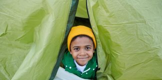 Menino sorrindo dentro de uma tenda