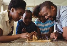 Família sorrindo enquanto jogam xadrez